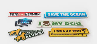 Assorted printed bumper stickers and die-cut vinyl stickers laid out on a white surface